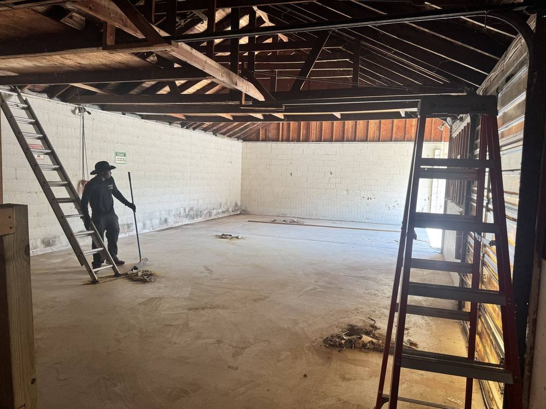 G.M.W crew member sweeping out a garage